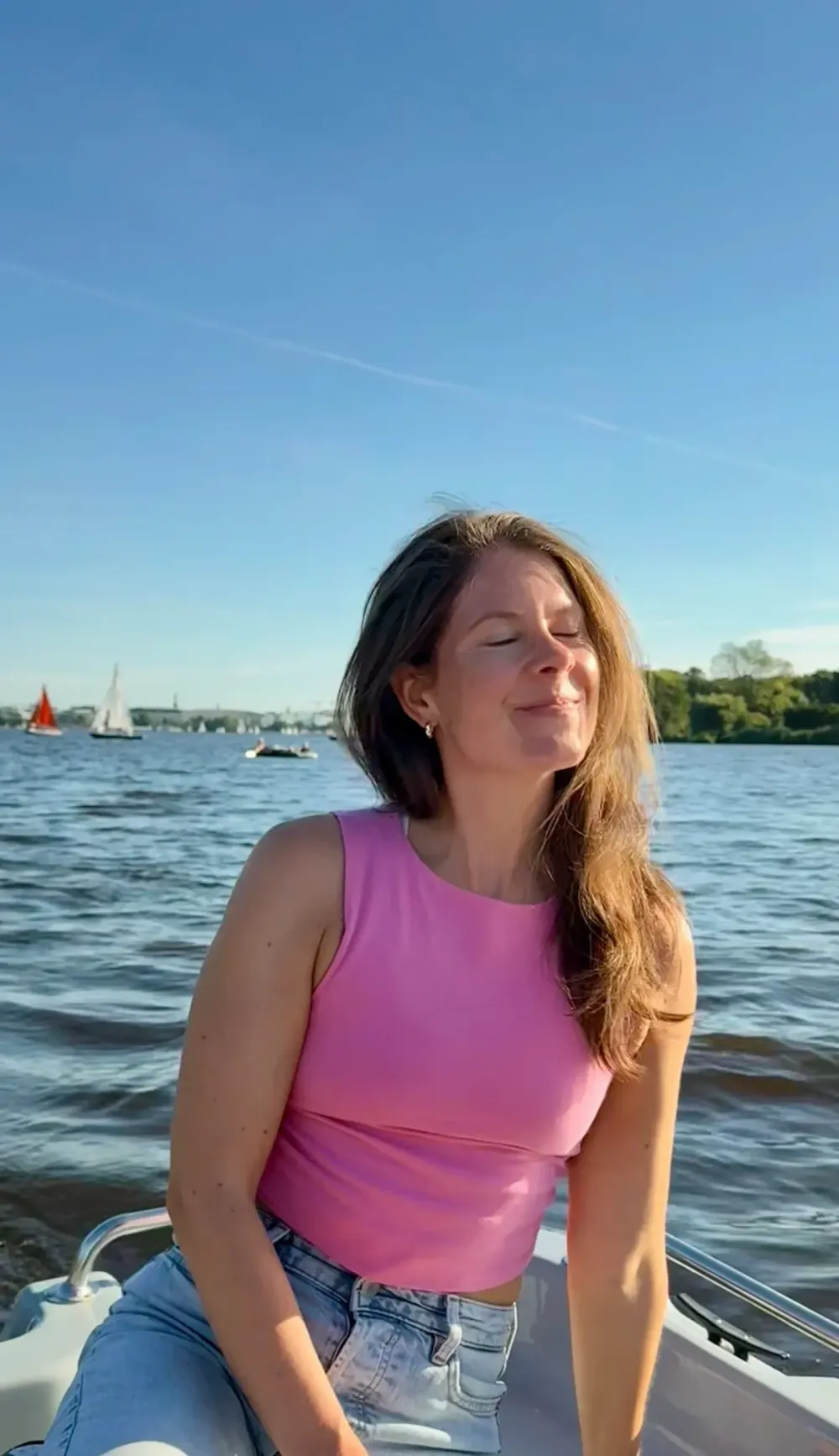 Jana Bardenhagen, Gründerin von soulfulspace, lächelnd auf einem Boot in der Abendsonne